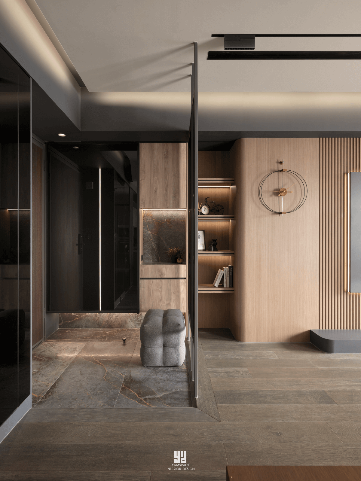 泰御天鑄室內設計：台中新成屋玄關落塵區，以深色紋理石材地坪銜接溫潤木質格柵牆，結合圓弧曲面收納櫃、穿鞋椅與隱藏式燈帶，形塑現代極簡空間層次感。